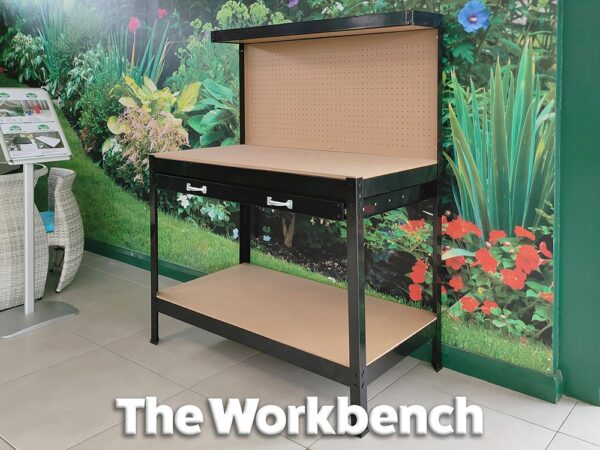 The black, powder-coated workbench with ply backing board against a green wall. Text on the image reads 'the workbench'