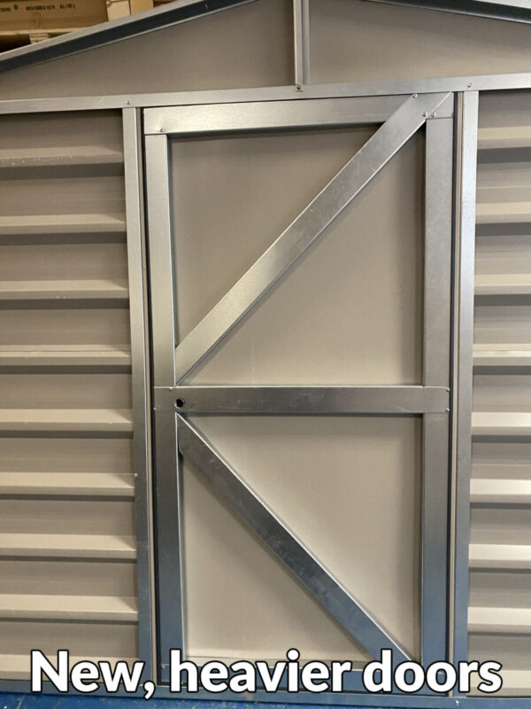 A heavy looking steel door with two 45 degree braced bars and a thick centre bar connecting them. Text at the bottom of the image reads 'new, heavier doors!'