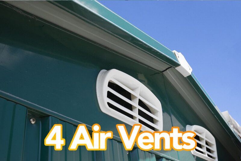 An exterior picture of a class green shed with the focus on the two front air vents. The shed is green, the vents are white and there is a cloudless blue sky above. Text on the image reads '4 Air Vents'