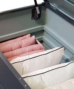 Inside the steel patio box. The box is open, the lid is visible and there are lots of cushions that are pink and white neatly lined up inside.