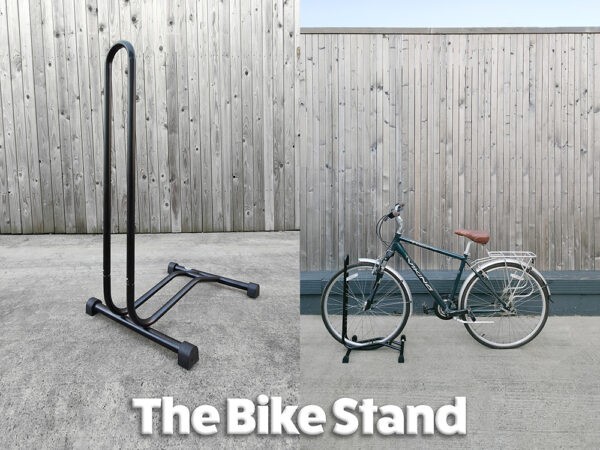 Two photos of the bike rack side by side. The first is a close up look at it. It's a tall, L-shaped unit, with smooth edges. It's entirely black and has two stands for support at the bottom. The picture on the right shows a bike stored in it.