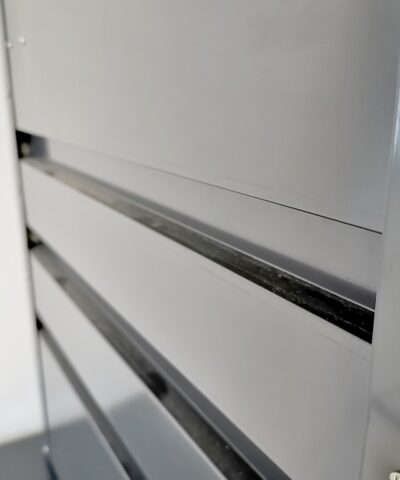 The Side of a Garden Storage box. The thick rivets can be seen on the side of the dark grey steel metal.