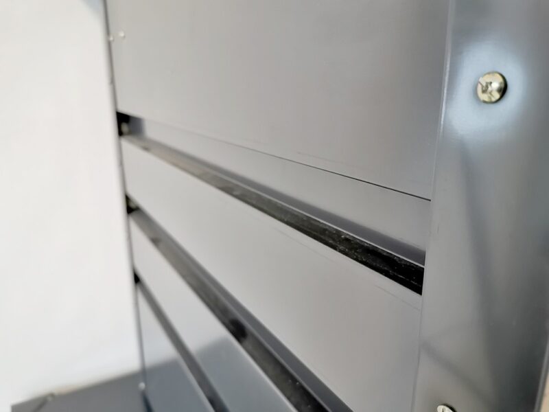 The Side of a Garden Storage box. The thick rivets can be seen on the side of the dark grey steel metal.