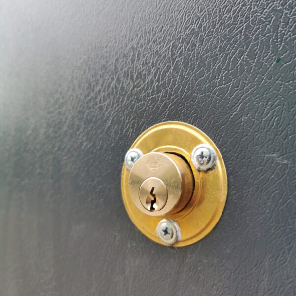 The new built in keylock on the PVC Cladded sheds from Sheds Direct Ireland in Dublin. The lock itself is circular and gold and it protrudes from the door by about one inch. There is a circular mount around it that is also gold and three screws attach this to the wall.