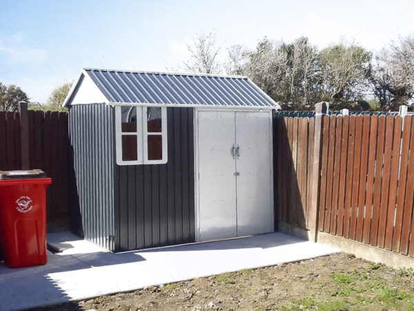 The 8ft x 6ft Steel Cottage shed in a customer's garden with two wheelie bins to the left of it