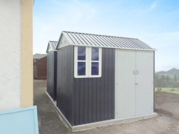 8ft x 6ft cottage garden shed in a large garden with a view of the mountains in the background