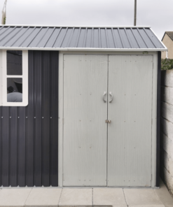 A cottage shed as seen from the front, with the door closed