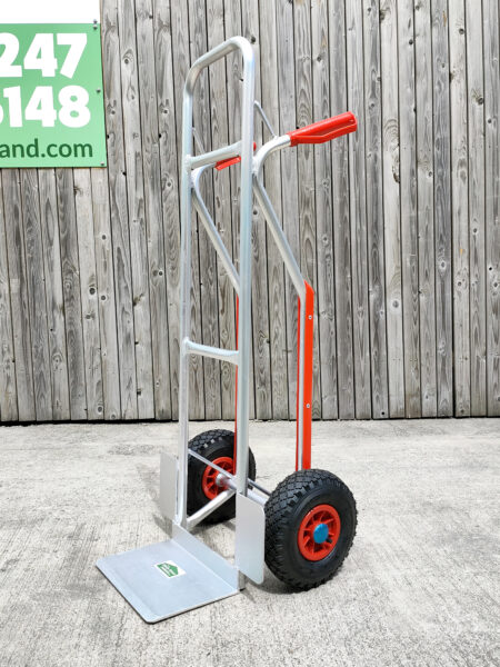 An aluminium hand truck with a chassis and red handles, red knuckle guards and wheel protectors