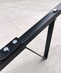 a detailed view of the triangular stand which is connected to the handle. This allows the trailer dolly to stand upright when not in use. The handle is connected to the wheels and axel and because of this bar, it raises at a 30 degree angle