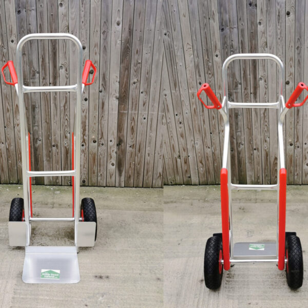 A front and back view of the Aluminium Sack Truck. The item is silver, except for the wheels which are black and the red handles and knee supports.