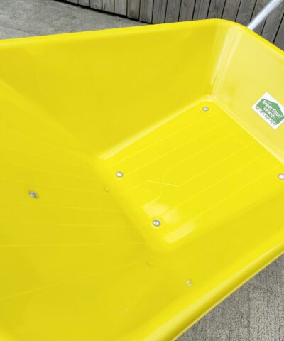 A detailed view of the bucket on the yellow wheelbarrow