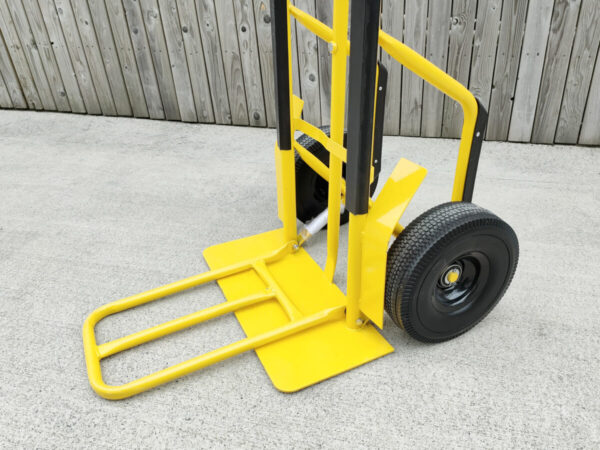 A close up view of the side of the yellow hand truck