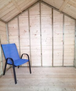Interior view of the chalet shed as seen from the door. There is a blue deck chair on the left side of the image. The walls and floor are made of a pale golden-pink wood. The frae edges are a darker colour and some have printed numbers on them in a very faded black ink.