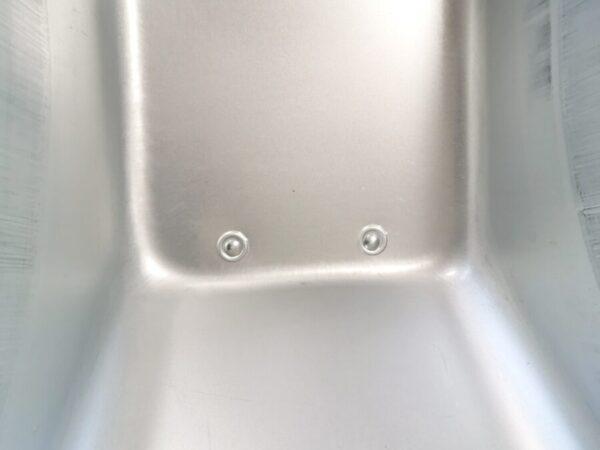 The internal detail of the barrow on the steel wheelbarrow. It's polished steel with 5 covered rivits visible.