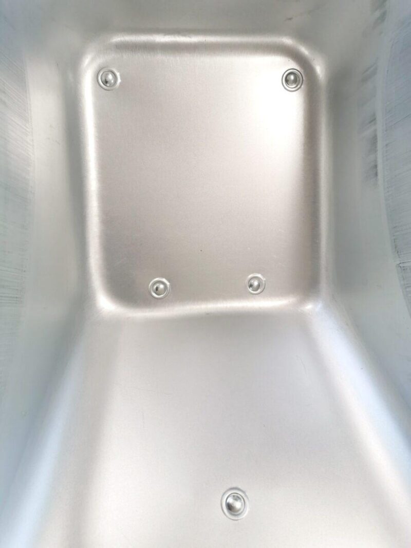 The internal detail of the barrow on the steel wheelbarrow. It's polished steel with 5 covered rivits visible.