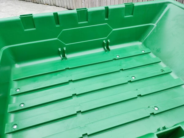 The internal bucket of the 250L Tip Cart. It's bright green and ribbed for grip. The side walls and deep and have little port holes on each end too