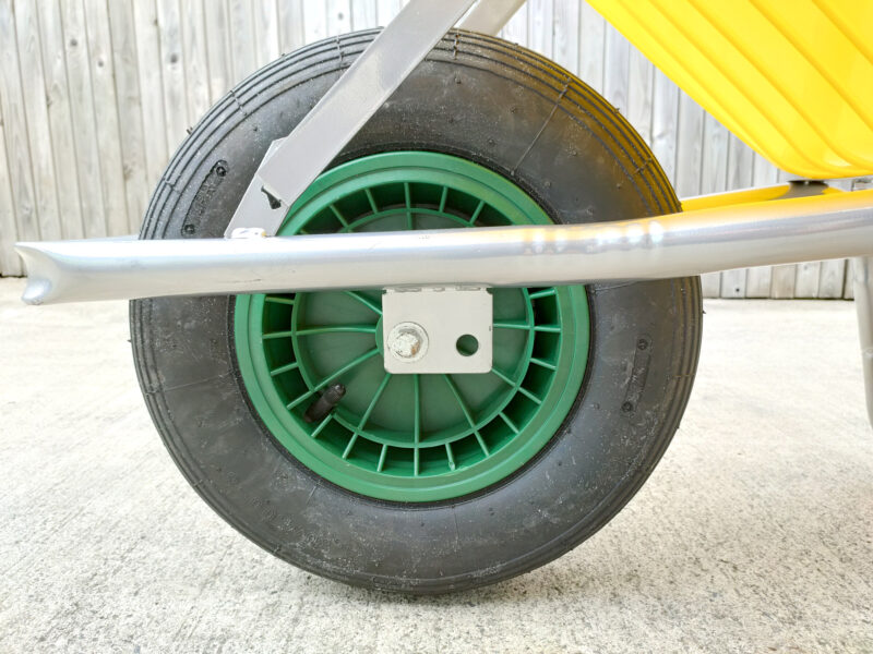 The black-grey tyres on the 90L wheelbarrow with a green alloy centre and thick silver bars connecting it to the tub