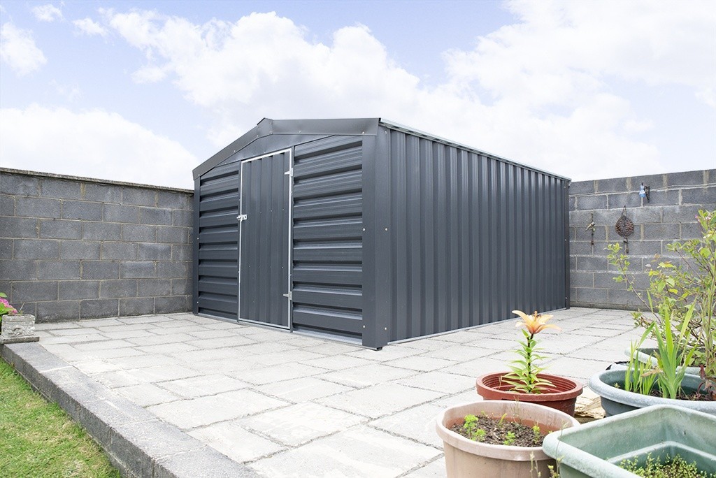 A Sheds Direct heavy duty PVC Cladded Shed in a customer's garden, against a wall with flowerpots in the foreground and a lawn to the front
