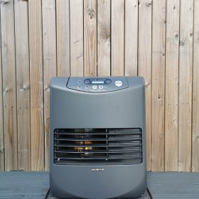 The Inverter 5086 Heater against a wooden backdrop wall. It's at eye level and you can see the heating mechanism through the grate inside.