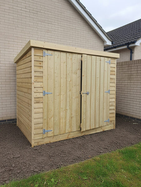 The wooden bike shed front and side with doors slightly open