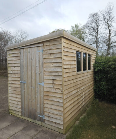 a look at the front and side of a cabin shed with three windows