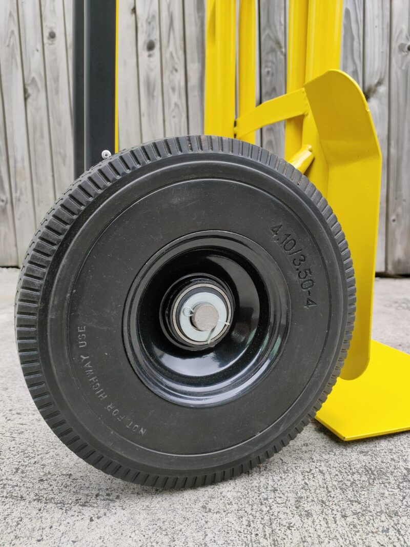 The large, solid, non-puncture wheels on the industrial hand truck