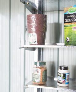 Metal Took Shelves mounted on the inside of a steel shed. There is a blue and green box of bird seed, a pack of plastic plant pots, an orange box of grass seed, a small white jar of 'loco coco' and a purple, wine-bottle shaped bottle of 'Orchid Mister' on the shelves. The ehslves themselves are a patchy steel.