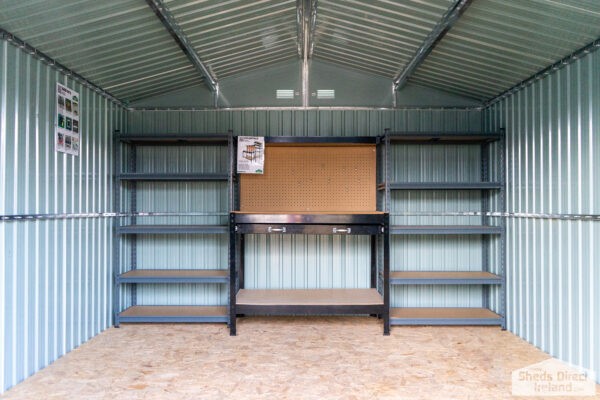 Shelves inside steel shed beside a metal work bench. There are 5 tiers and the tiers have wooden bases.