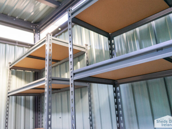 Shelves inside a steel shed. There are 5 tiers and the tiers have wooden bases.