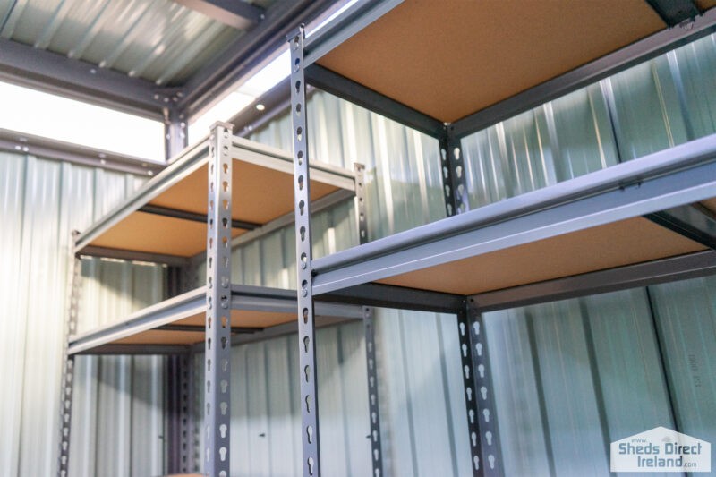 Shelves inside a steel shed. There are 5 tiers and the tiers have wooden bases.