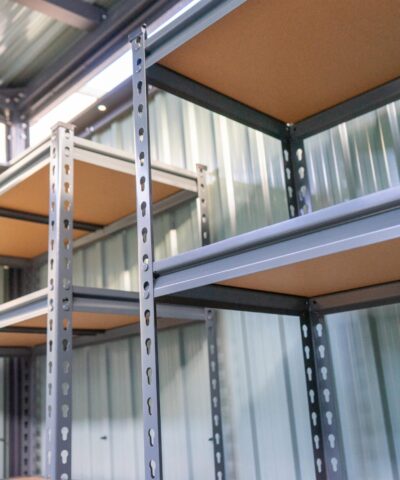 Shelves inside a steel shed. There are 5 tiers and the tiers have wooden bases.