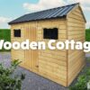 Wooden cottage shed. outside in gravel. light brown in colour.