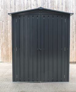 The front view of the small shed. It is grey-black and it has a sloping, peaked roof. The gutters overlap on the shed by about 3 inches either side.