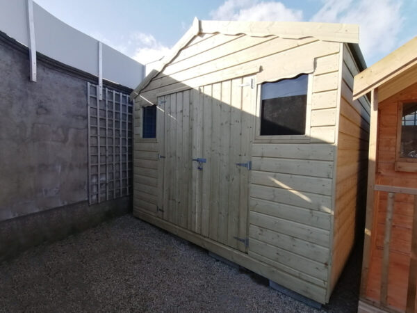 A variant of the Tall Wooden Shed which has two windows on the front. There are double doors, 'scallops' above the windows and a peaked roof. The shed is a golden-yellow colour.