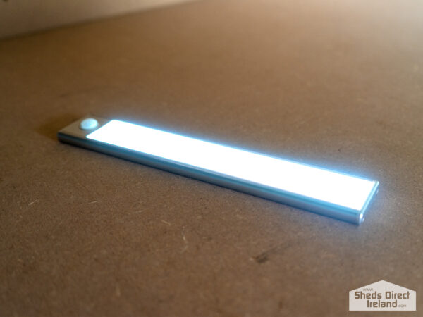A long, silver LED Light on steel shelving unit
