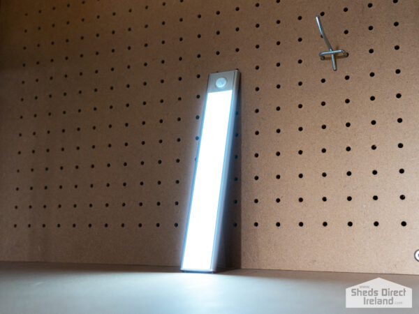 A long, silver LED Light on steel shelving unit