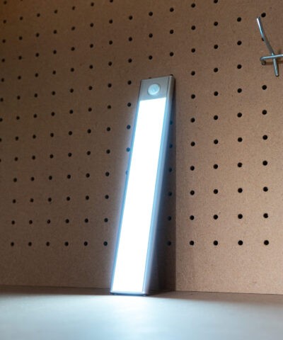 A long, silver LED Light on steel shelving unit