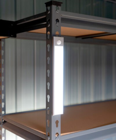 A long, silver LED Light on steel shelving unit