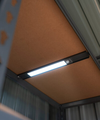 A long, silver LED Light on steel shelving unit