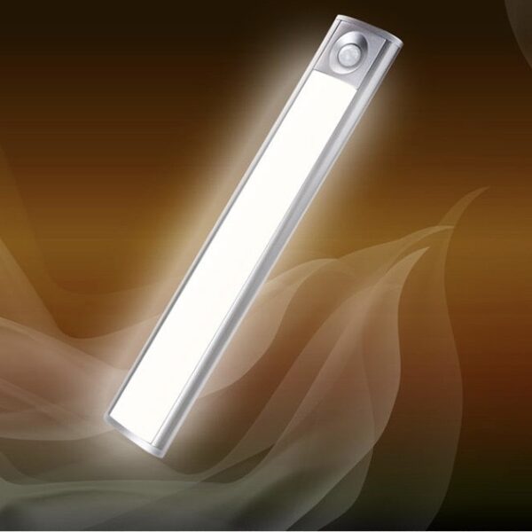 A long, silver LED Light at a 45 degree angle. It's illuminated and there is a golden swirl of smoke behind it.