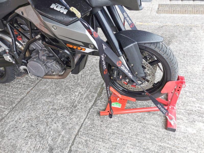 A side view of the bike in the sheds direct ireland motorbike stand. The straps are in use in the side ports, allowing the bike to freestand without assistance