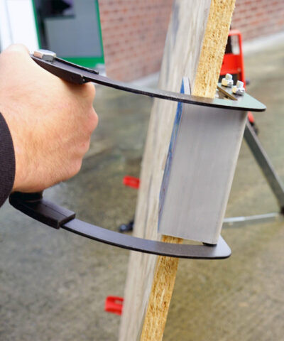 a hand holding the panel carrier with a sheet of ply in it at a horizontal angle