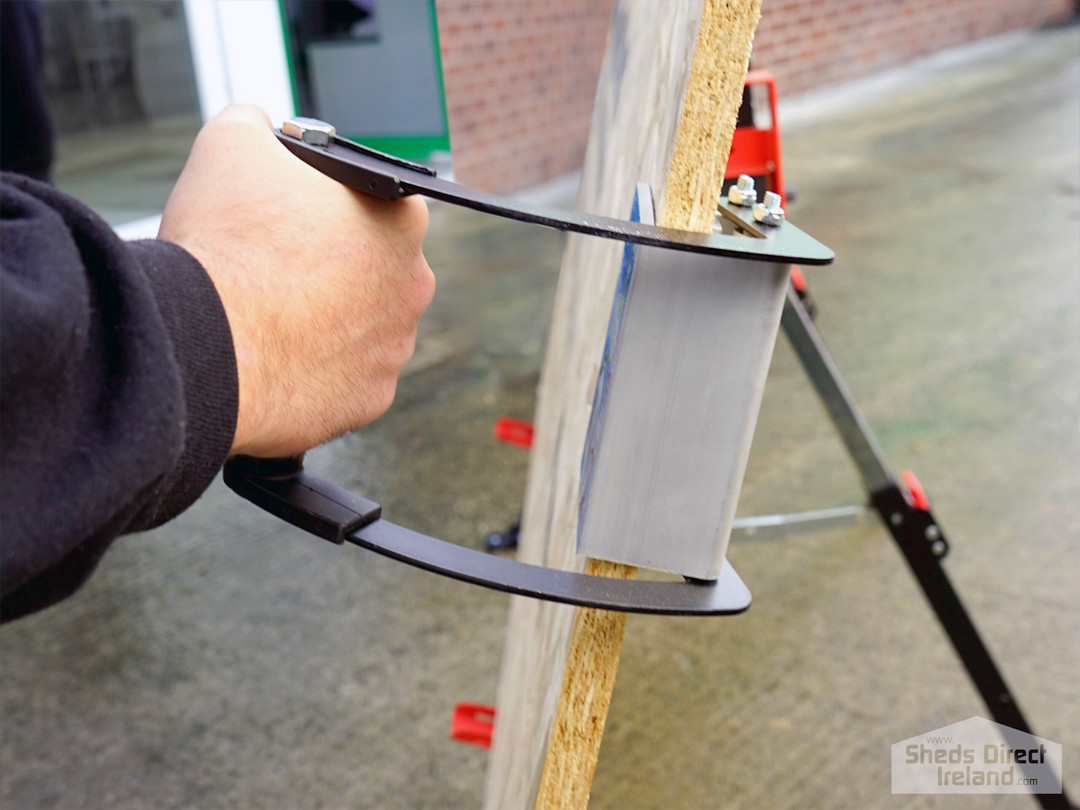a hand holding the panel carrier with a sheet of ply in it at a horizontal angle