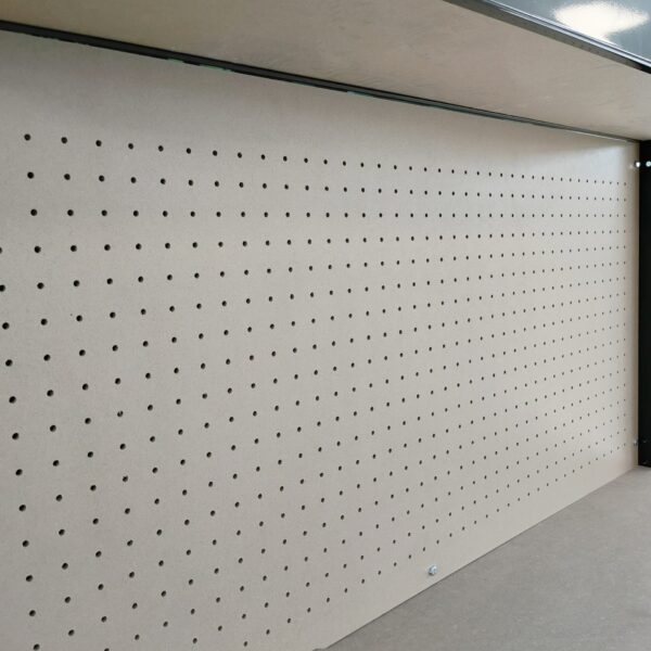 The pale pegboard backing of the work bench from Sheds Direct Ireland. It has over 700 holes to support tools with.