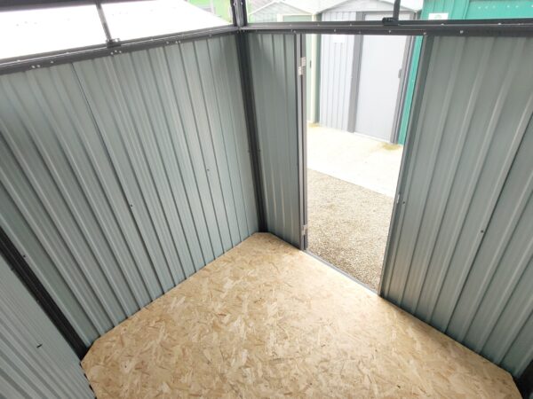 A view from the top inside corner of the shed looking inwards. The walls are grey and the floor is a pale-golden wood colour