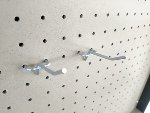 Two shiny grey tool hooks protruding from the pale wooden backboard of the sheds direct ireland tool shelf
