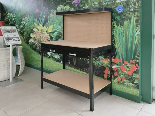 The black workbench from sheds direct ireland. It has four base legs, a low shelf, approximately 10cm off the floor. The tool drawer is 95cm off the floor and on top of this is a flat surface for working on. The back extends another 50cm up and it has holes on the backboard to attach tool hooks into.