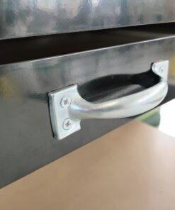 The pale grey handles of the work bench on the drawer