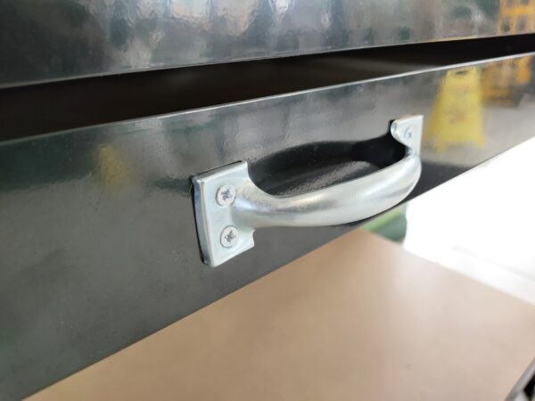 The pale grey handles of the work bench on the drawer