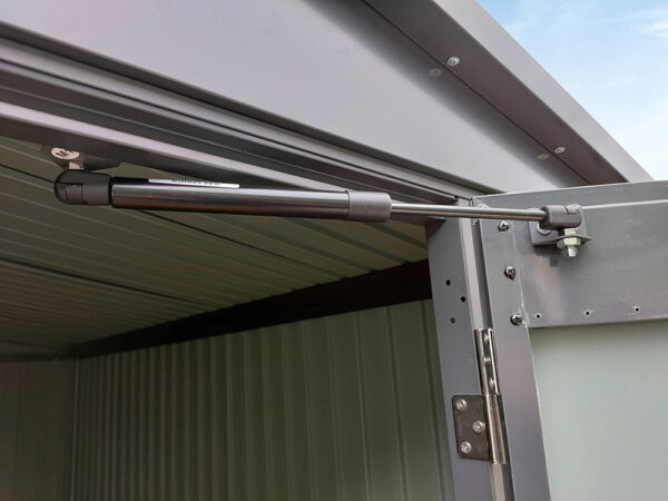 The gas-hinge on the door of the premium apex shed. It's above the door and connected to the nearest part of the door connected